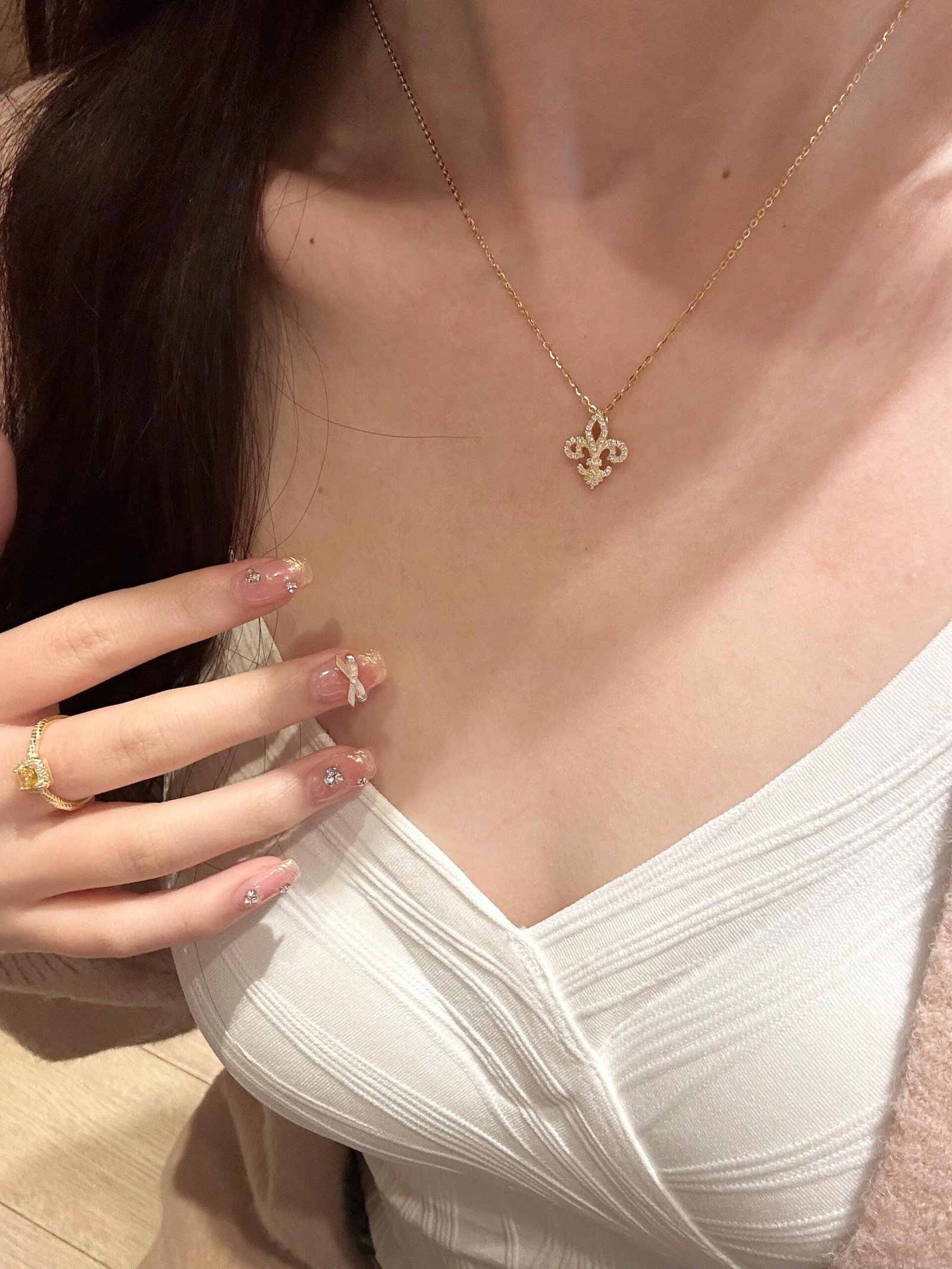 Fleur de Lis Moissanite Necklace worn along the collarbone
