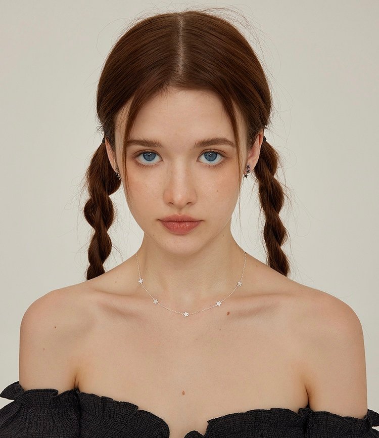 Sterling silver star necklace worn on the neck showing delicate five-point stars