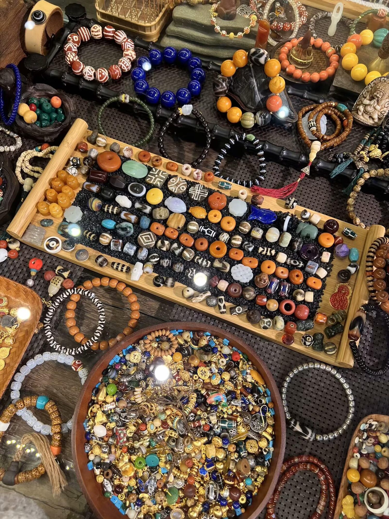 Variety of beads and bracelets arranged on a handmade jewelry market table