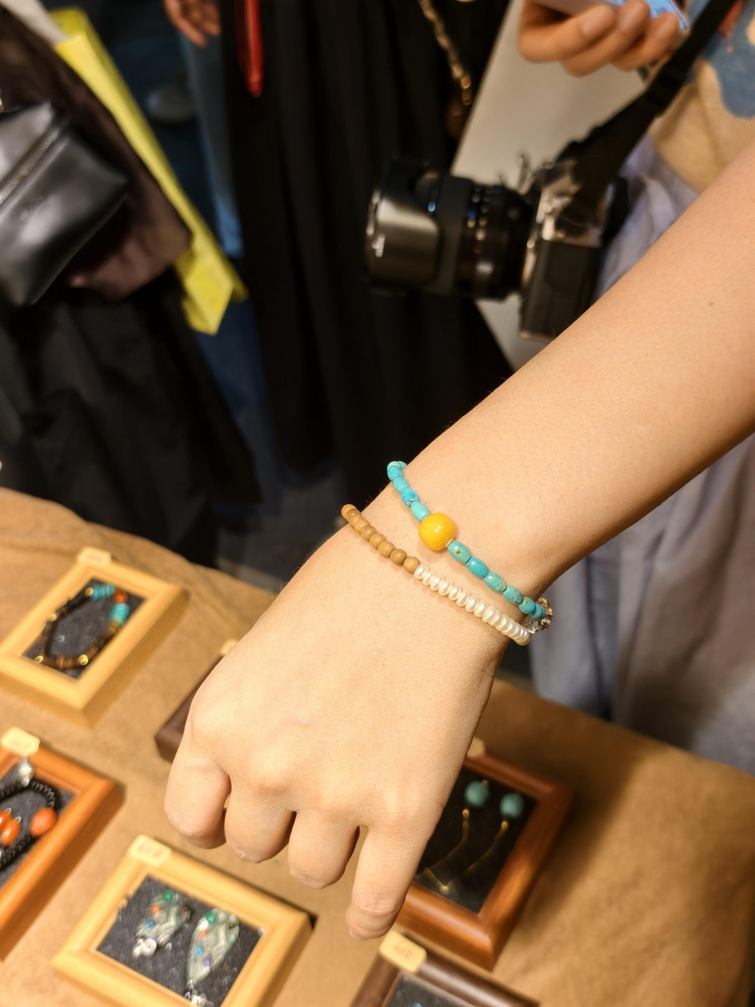 Visitor trying on a colorful beaded bracelet at a jewelry market