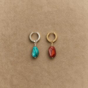 Freeform turquoise and Nanhong agate drop earrings with platinum-plated and gold-plated silver hoops on a beige background.