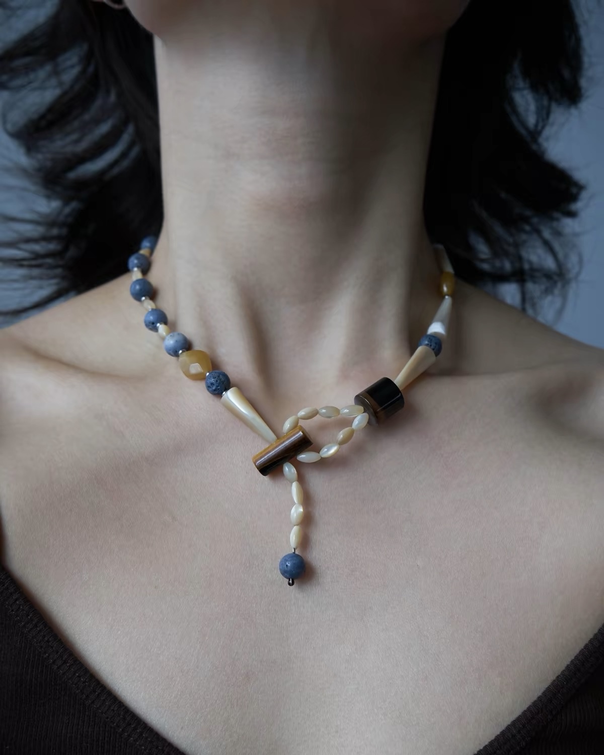 Blue Rhythm natural stone necklace with blue beads, cream shell details and a front-loop pendant worn around the neck.