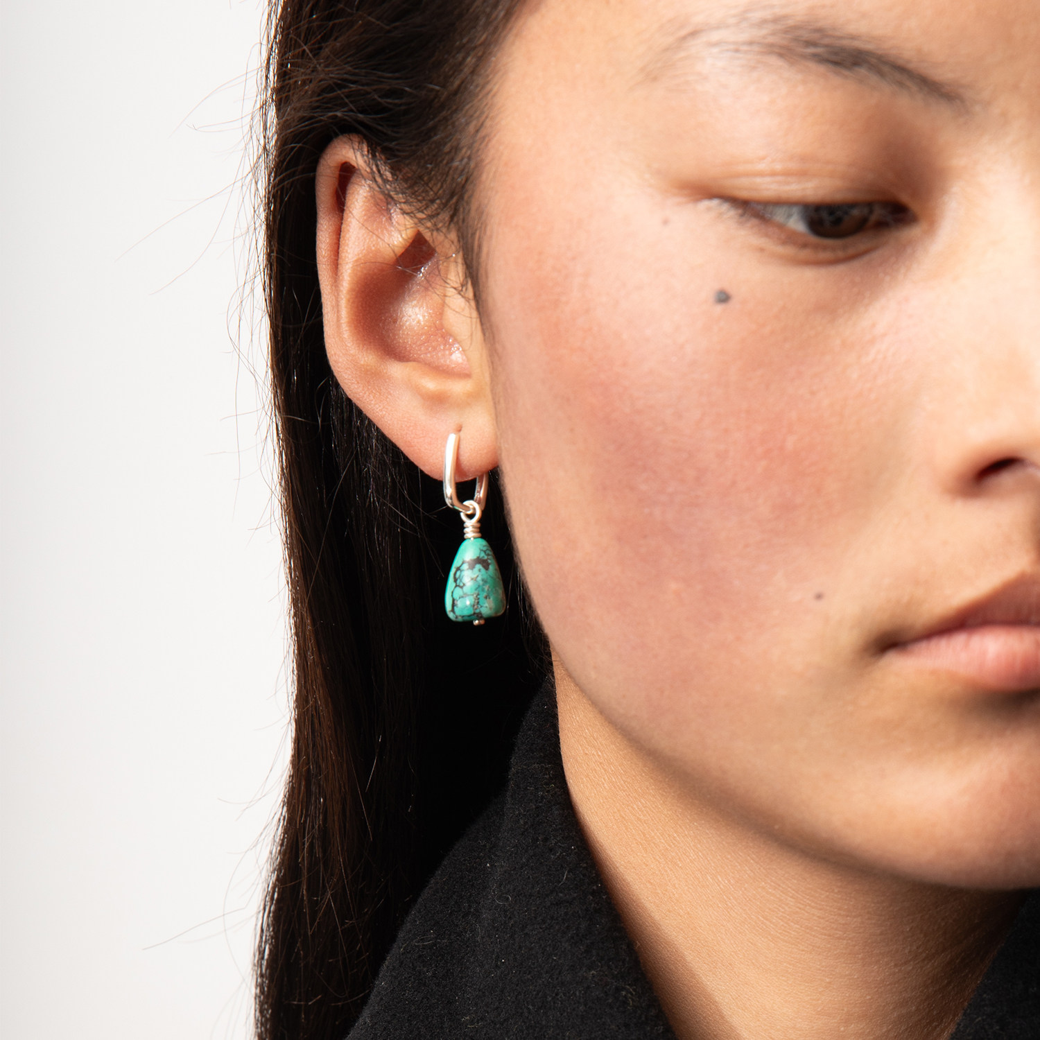 Woman wearing a natural turquoise drop earring