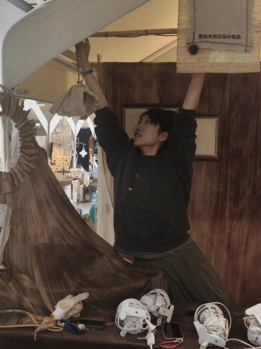 A maker setting up the RONGHUA booth before the market opens