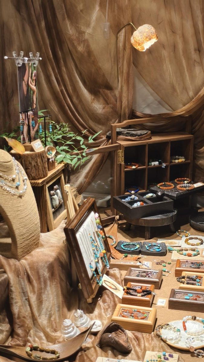 A styled section of the RONGHUA market display with jewelry arranged on wood and fabric