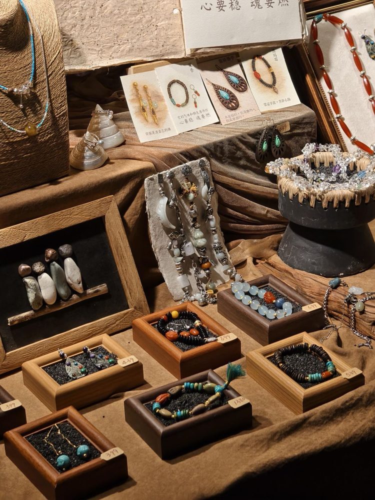 A close-up section of handmade bracelets and necklaces on the market table